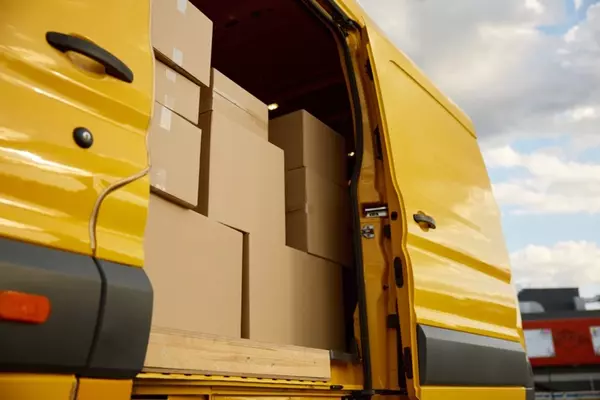 Open back of a yellow delivery van filled with packages, signifying parcel to Malaysia