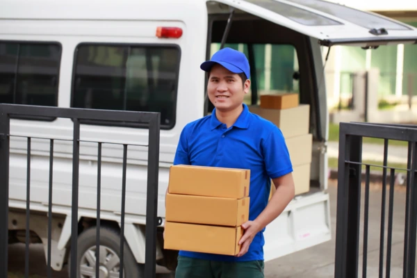 A worker from a logistics company delivering a package to its customer