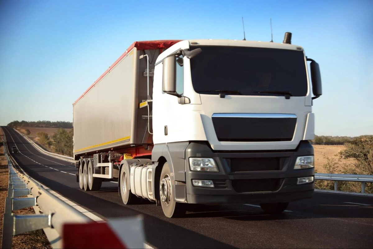 Cross-Border Freight Truck on Highway White cargo truck and trailer travelling on a highway, representing cross-border freight transport